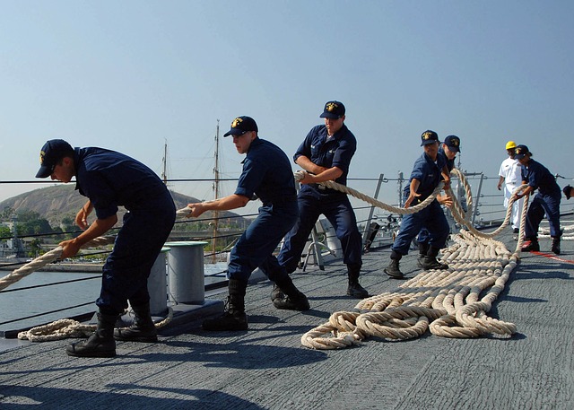Sailors pulling rope on boat