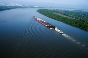 Aerial view of a barge navigating the Mississippi River in Baton Rouge, Louisiana.