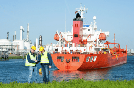 two maritime workers standing beside a barge on the water