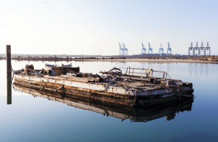 An unseaworthy barge floating offshore
