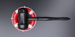 Maritime law concept featuring a navy ship lifebuoy and judge's gavel on a black background, top view.