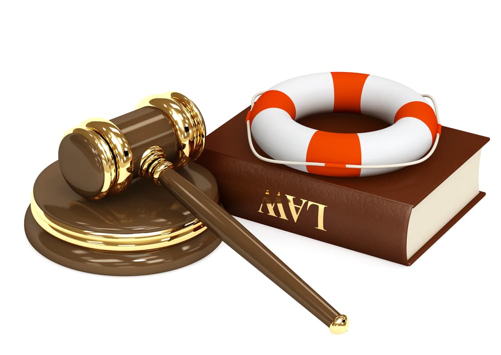 A lifebuoy, hammer, and legal book represent the concept of legal aid, symbolizing protection, justice, and guidance in maritime and legal matters.







