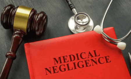 Medical Negligence handbook beside stethoscope and judge's gavel.