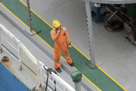 A deckhand standing on a harbor deck.
